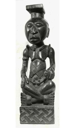 Statuette of Ngoulou-Viti seated cross-legged and holding a knife or beater