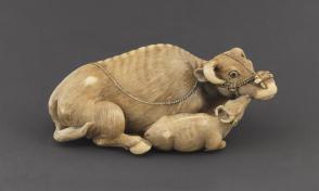 Netsuke modeled as a recumbent cow and calf