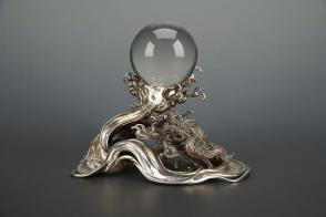 Rock crystal ball on a dragon amid ocean waves