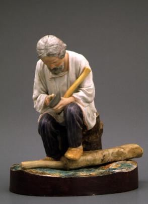 Figure of a man sharpening an axe