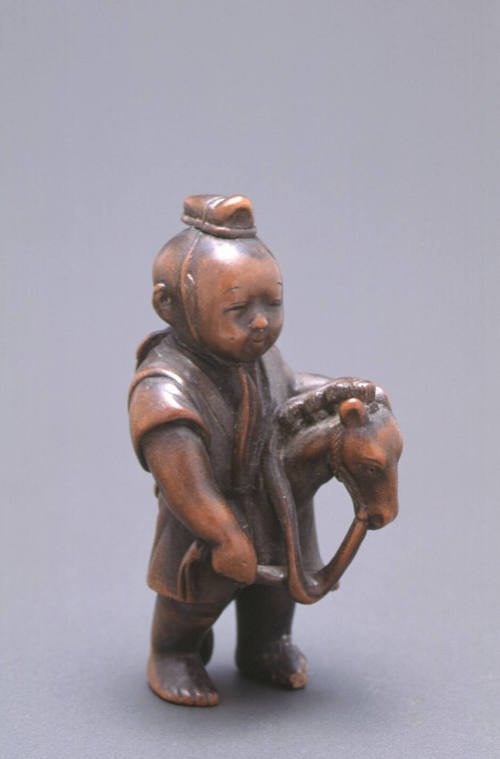 Netsuke modelled as a boy on a hobby horse
