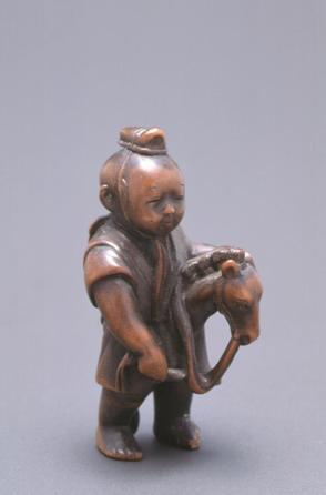 Netsuke modelled as a boy on a hobby horse