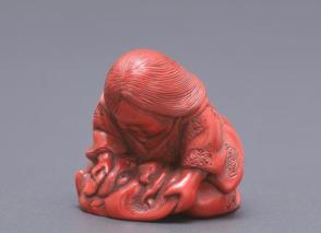 Netsuke modelled as a woman with an oni mask