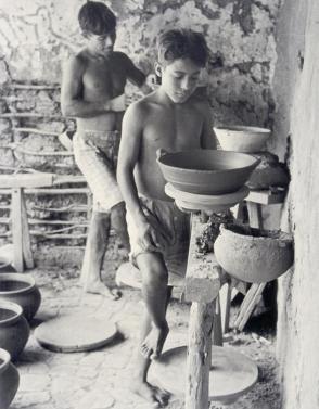 Pottery makers. Father and son work with a gray clay, from Amero Picture Book