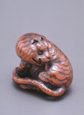 Netsuke modelled as a tiger licking its back