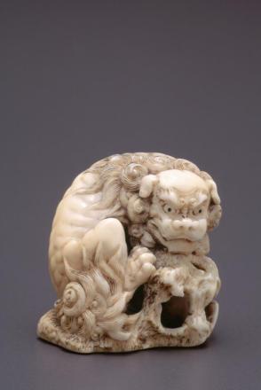 Netsuke modelled as a shi shi with ball