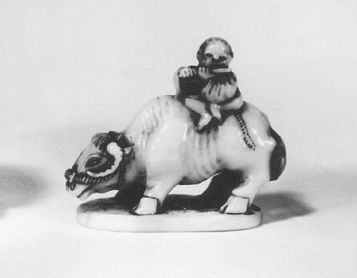 Netsuke modelled as a boy playing a flute astride a water buffalo