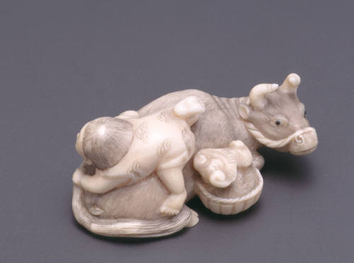 Netsuke modelled as a child astride a bull