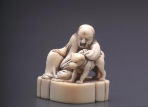 Netsuke modelled as a Chinese man sleeping against his dog